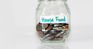 A jar of coins with a label that says house fund.